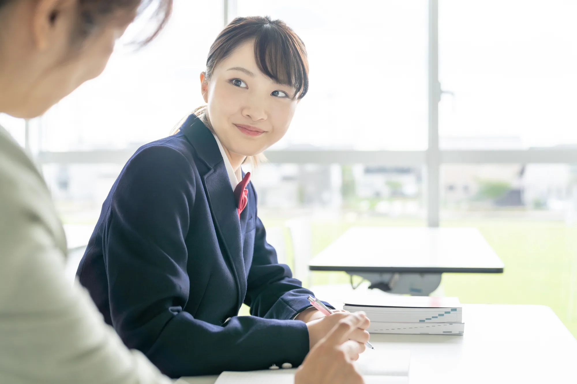 教室で先生と向き合う高校生