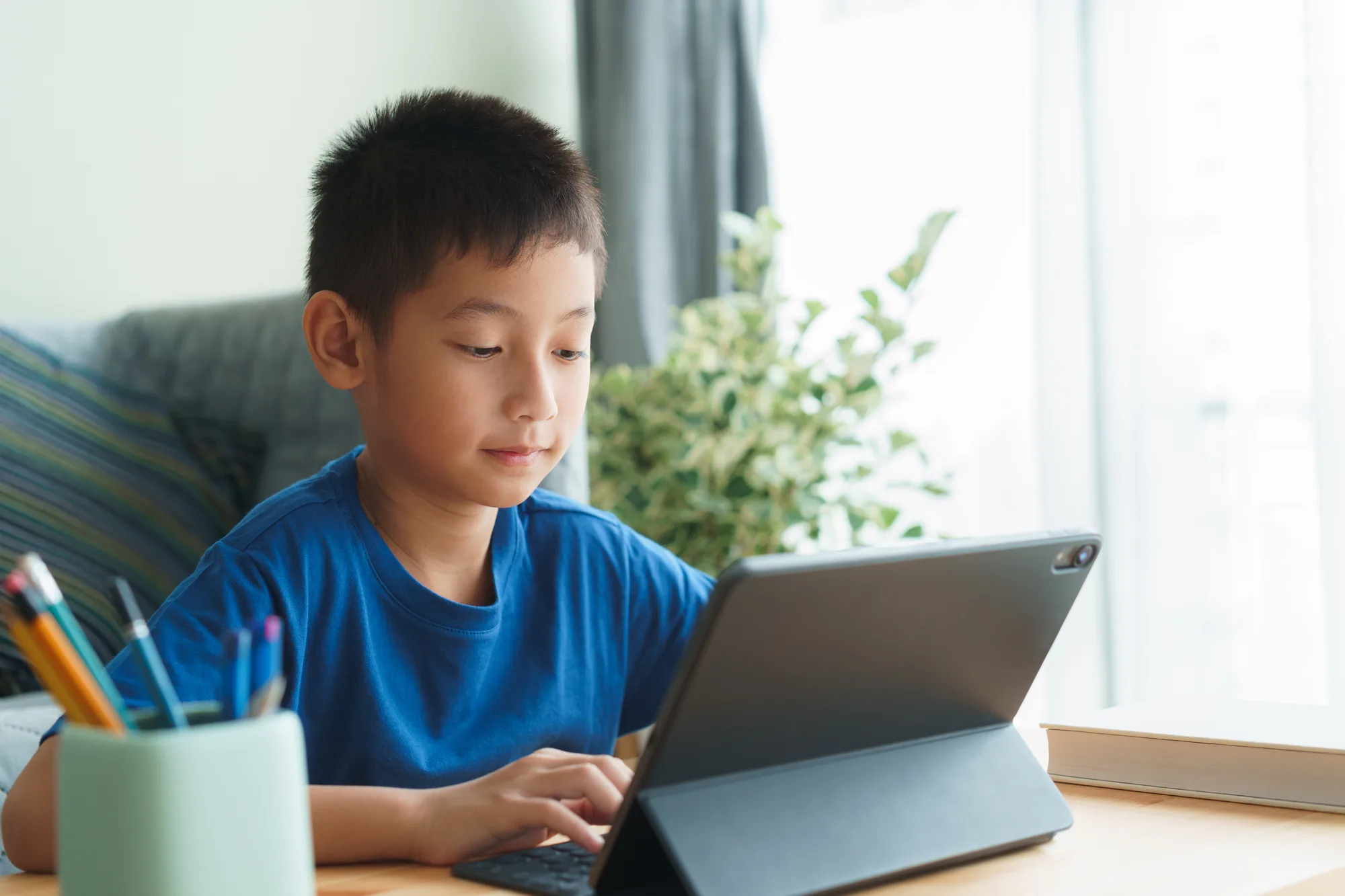 タブレットでオンライン授業を受ける小学生