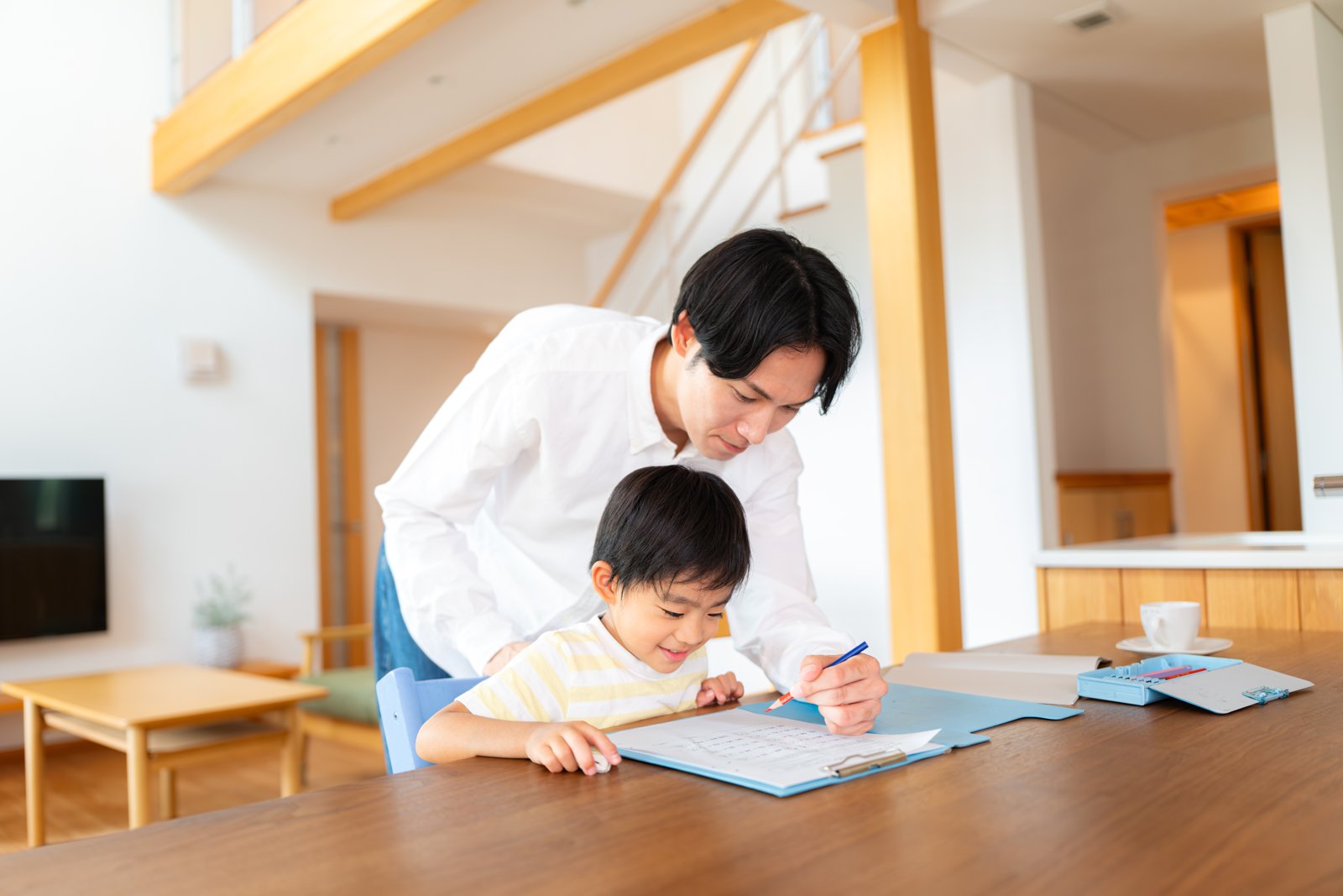 先生と一緒に学校の宿題に取り組む小学生